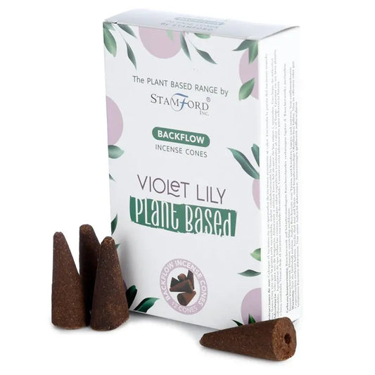 "Plant Based Backflow Incense Cones Violet Lily by Stamford Inc with white botanical packaging featuring soft purple circles and green leaf design, displayed with natural brown backflow incense cones"