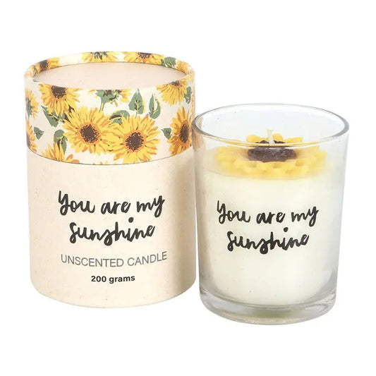 "You Are My Sunshine Candle with 3D sunflower decoration next to product packaging"
