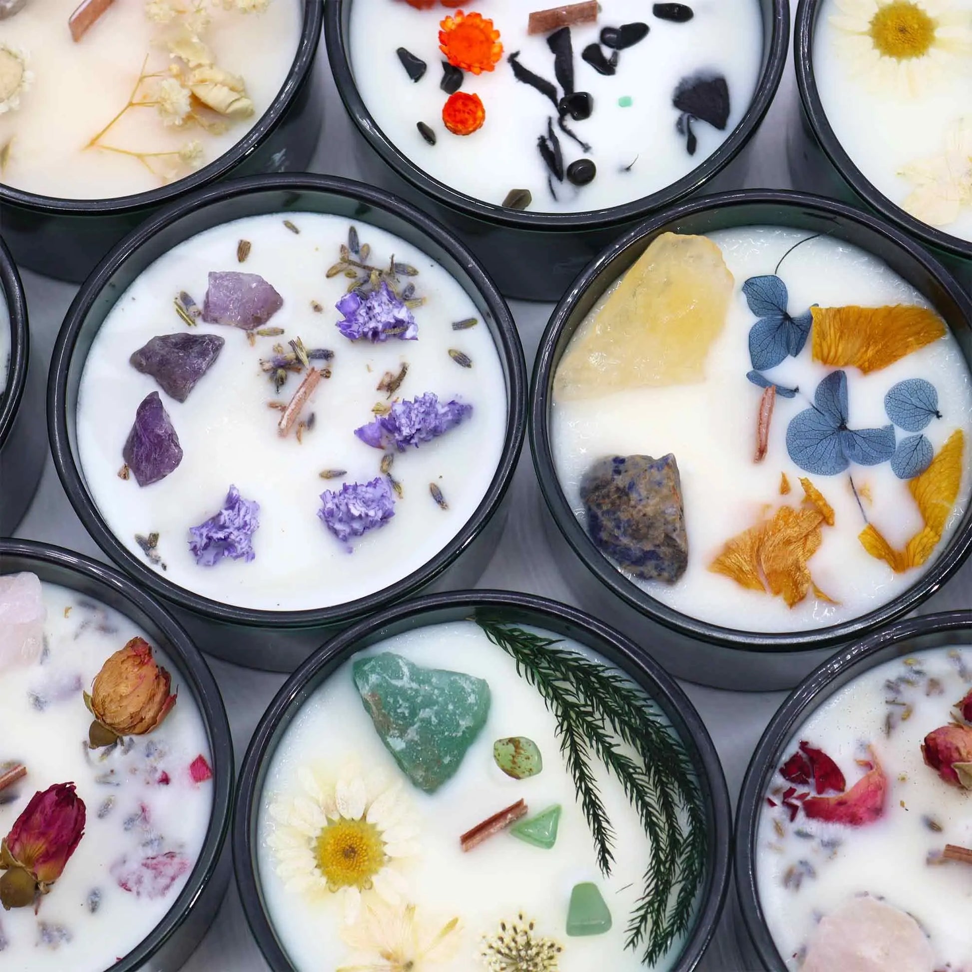 "Collection of Hop Hare Crystal Floral Candles showing different crystal and botanical combinations including amethyst, citrine, aventurine, and various dried flowers"