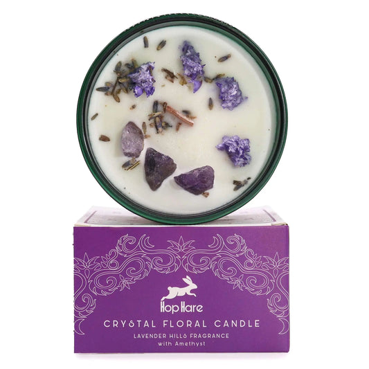 "Hop Hare Crystal Floral Candle in green glass vessel with amethyst crystals, lavender buds, and cinnamon sticks, displayed on purple Lavender Hills fragrance packaging box"